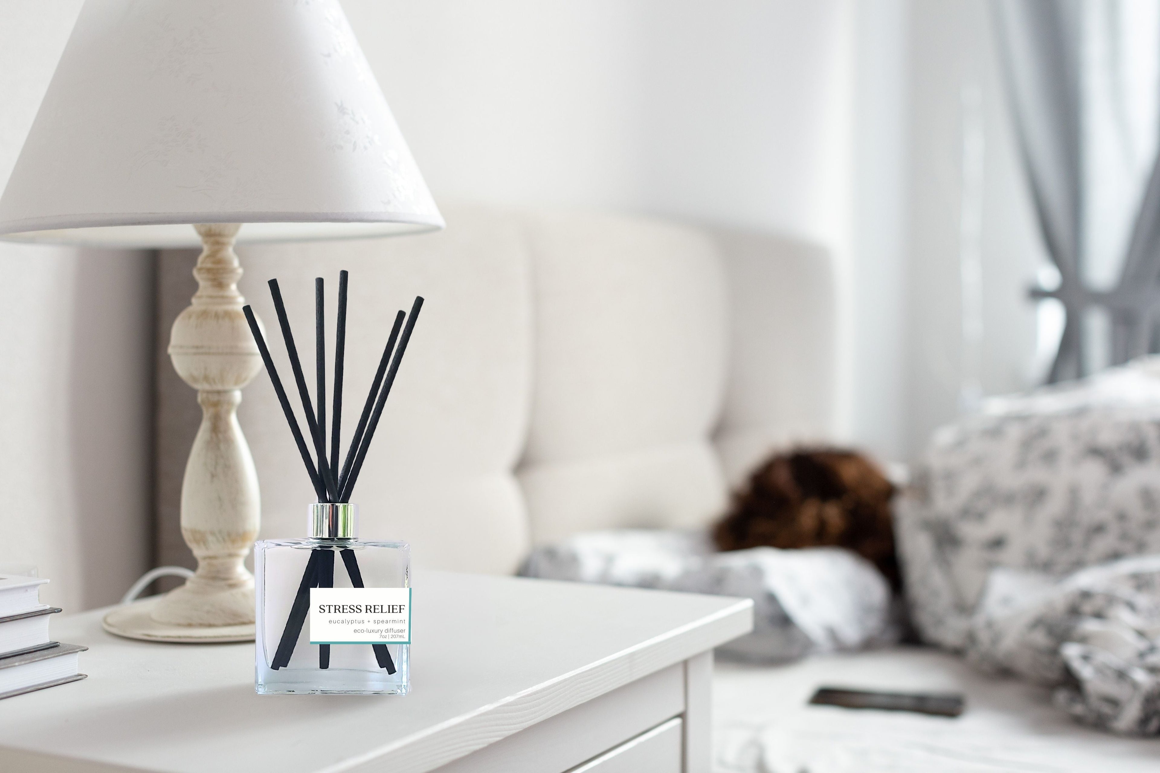 An image of Green Koala's stress relief nontoxic  reed diffuser on a night stand in a bed room.