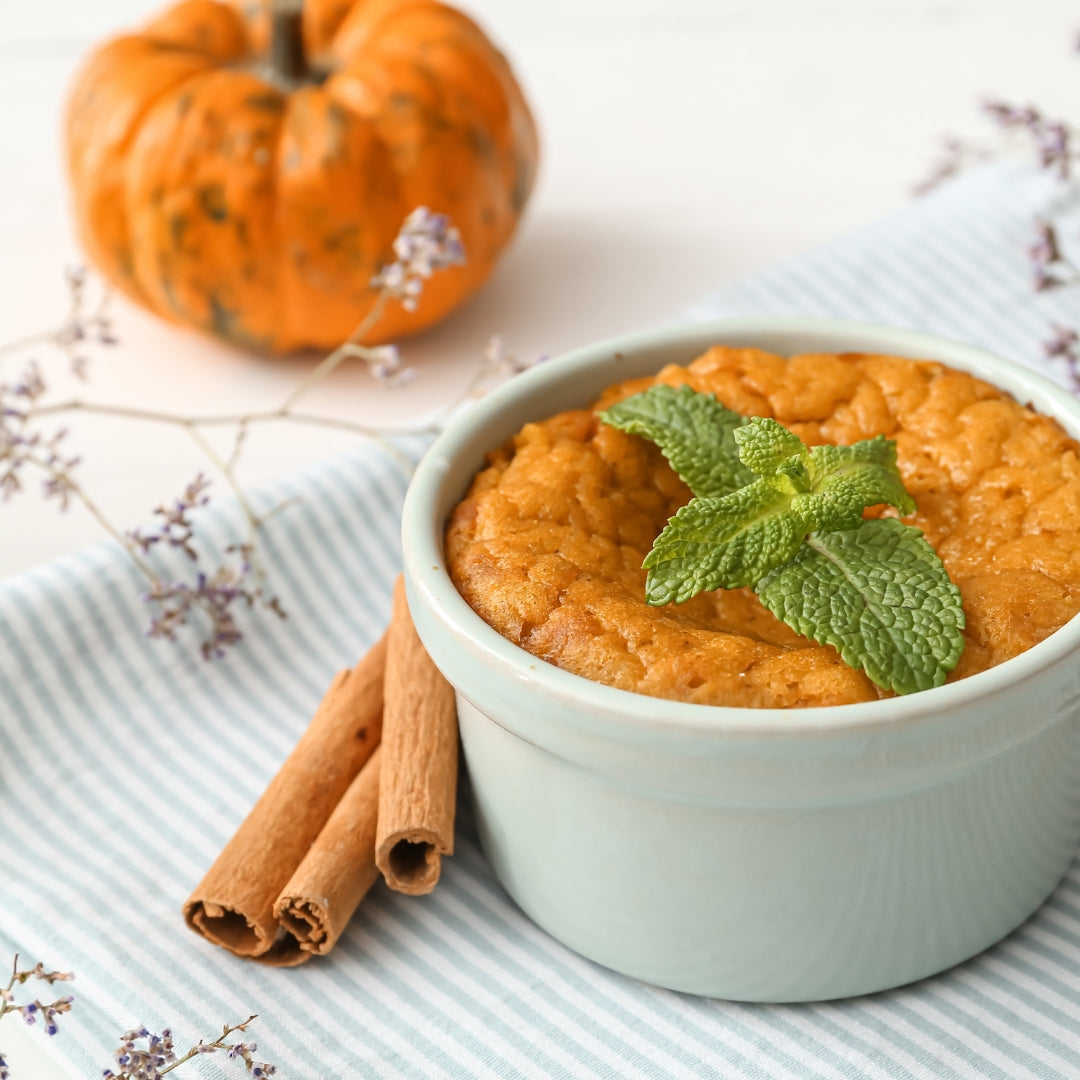Minimalist staged picture of pumpkin soufflé garnished with mint.