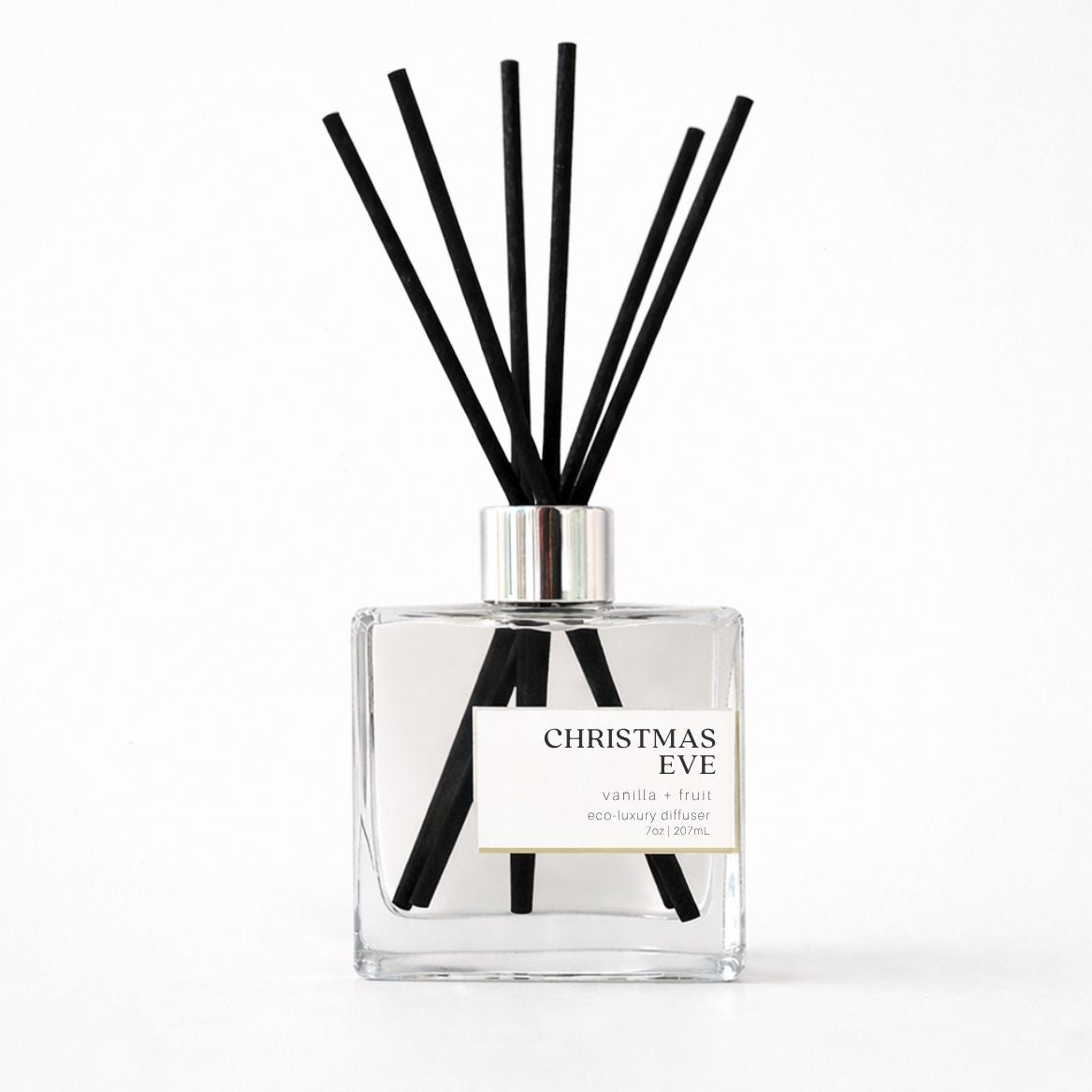 Clear diffuser bottle with black reeds labeled &