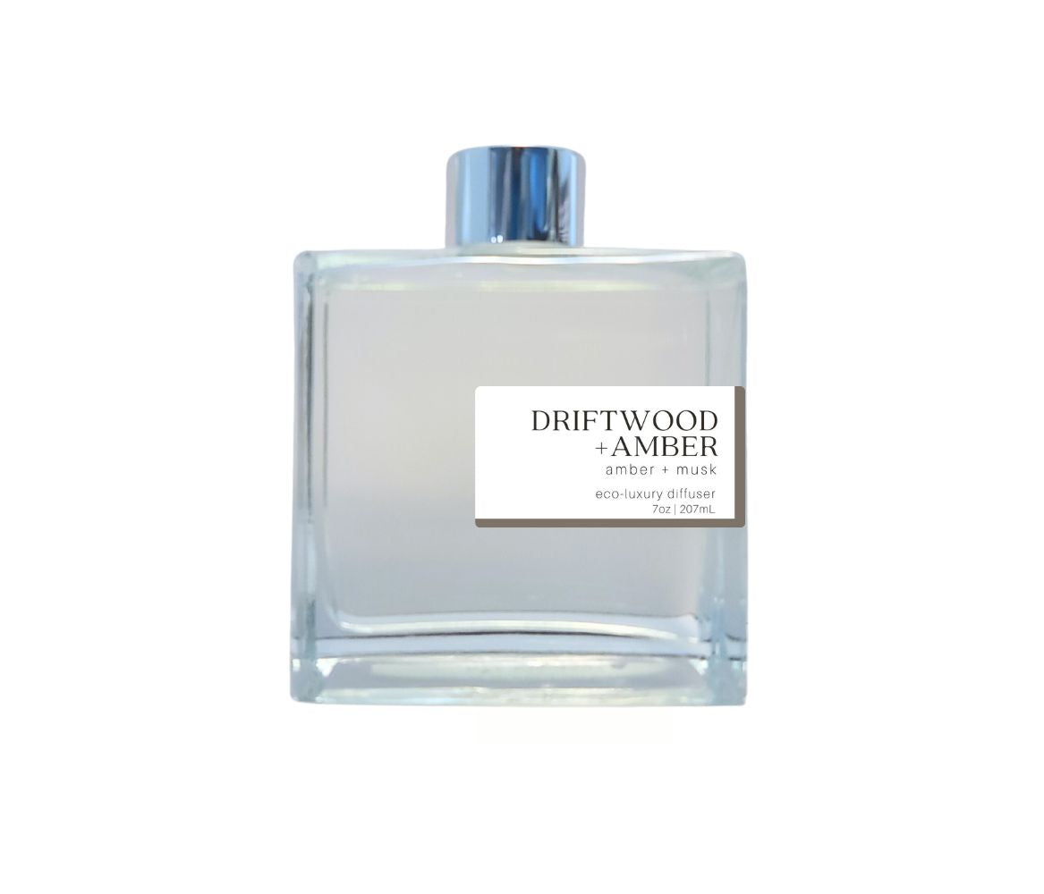 Hand-poured Driftwood + Amber reed diffuser in a sleek glass bottle with silver cap, offering a rich, natural aroma to enhance your home.