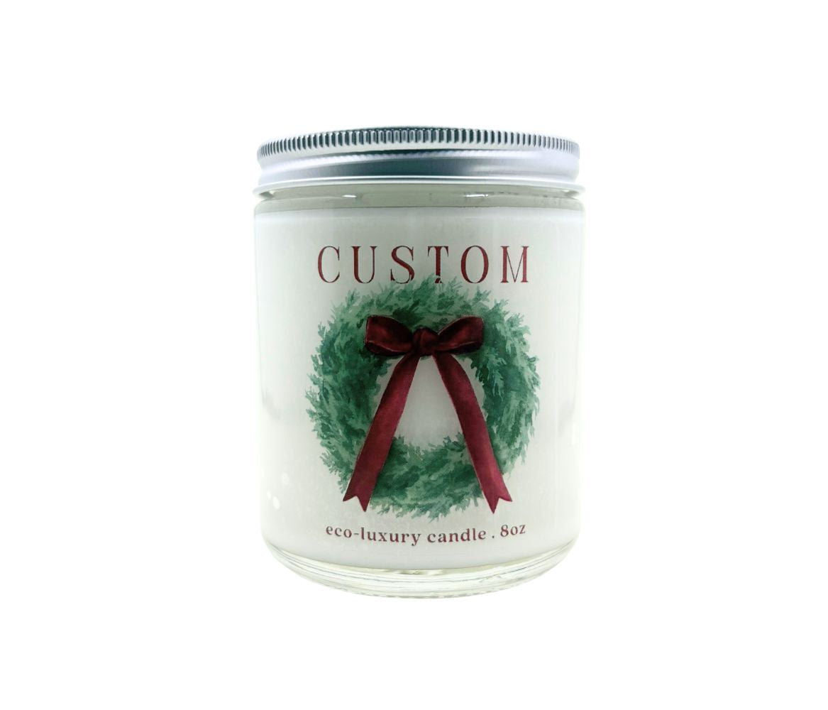 Image of a 8oz candle with custom label. The design is a large wreath with red bow. 