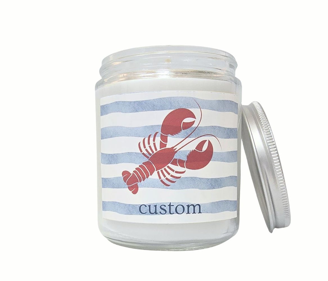 Custom 8oz coastal candle with red lobster icon and personalized beach town label on nautical blue striped background.