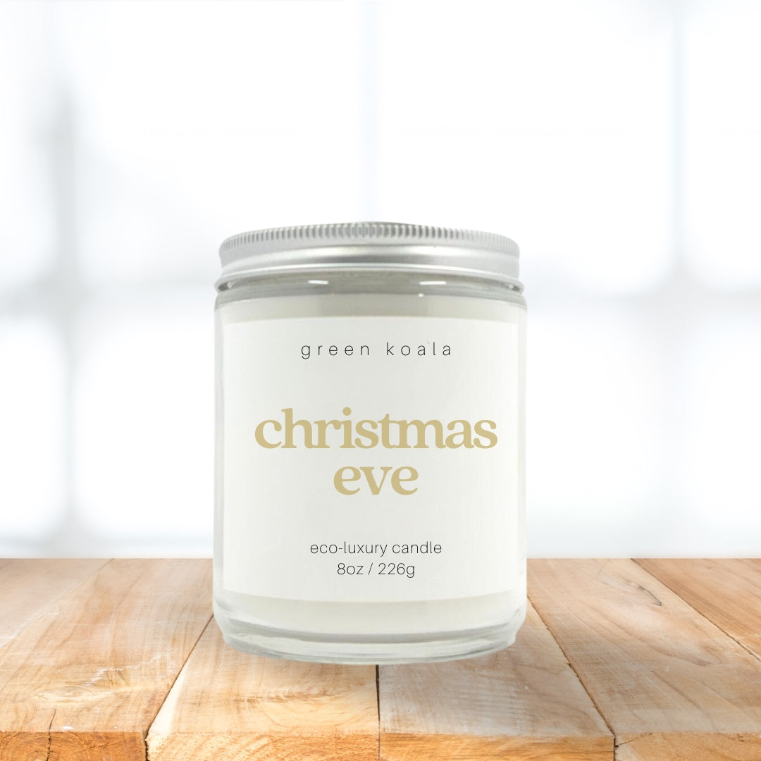 8oz Christmas Eve scented candle in a glass jar with silver lid. The label is in gold text.  