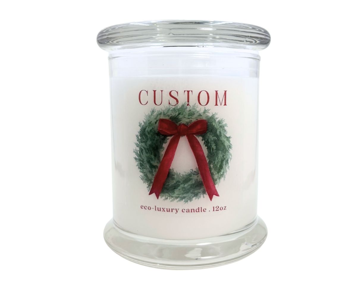 Image of a 12oz candle with custom label. The design is a large wreath with red bow. 