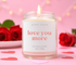 Love you more candle burning with a valentines day themed background