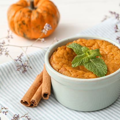 Minimalist staged picture of pumpkin soufflé garnished with mint. 