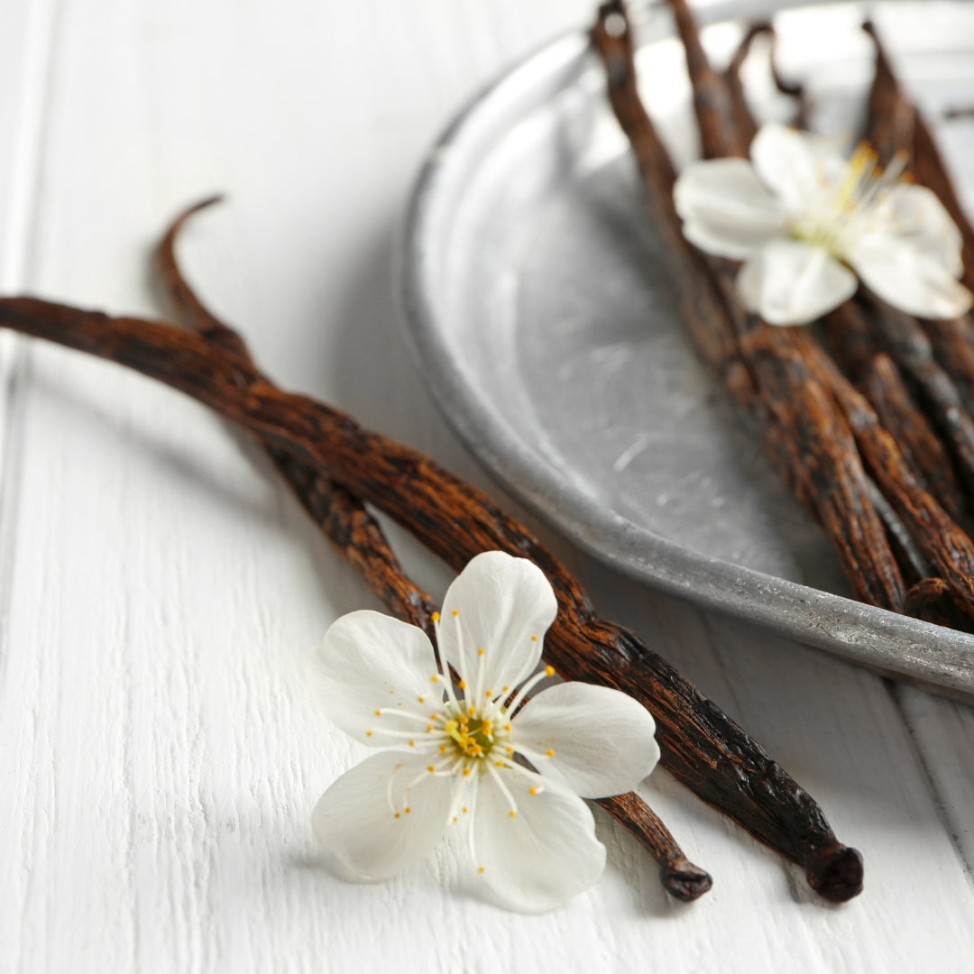 Stack of vanilla beans with blossoms.