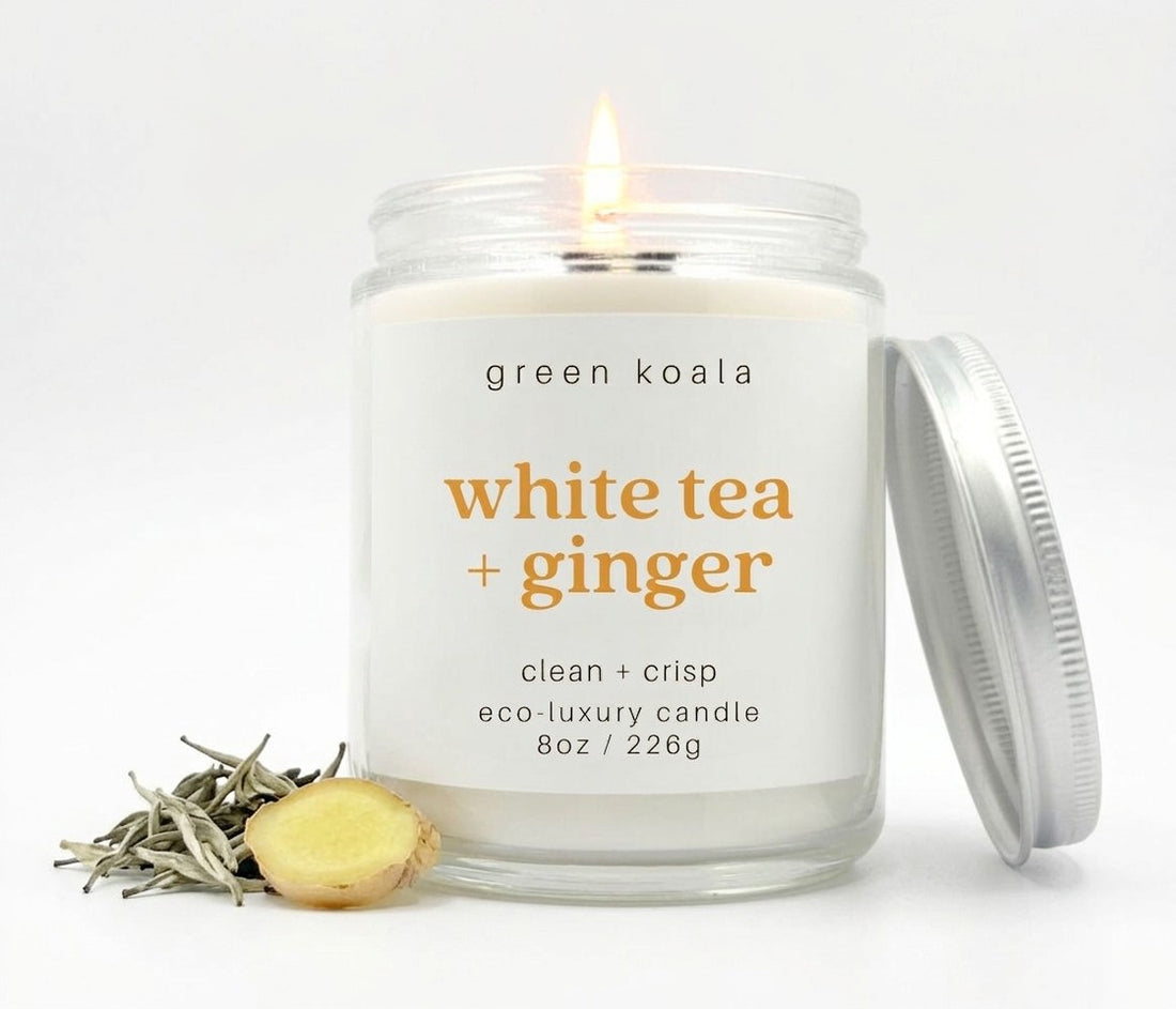 Image of an 8oz White Tea &amp; Ginger candle lit with some tea and ginger root embellishments.