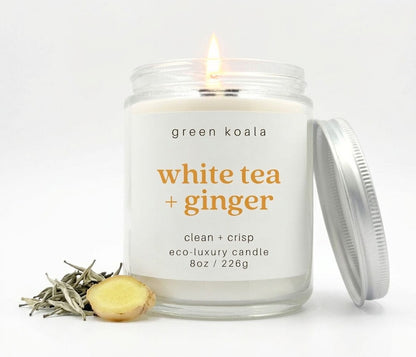 Image of an 8oz White Tea &amp; Ginger candle lit with some tea and ginger root embellishments.