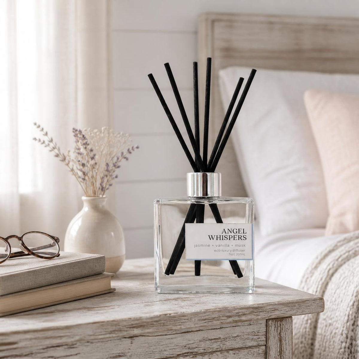Green Koala Angel Whispers non-toxic reed diffuser with black fiber reeds on a dresser in a rustic bedroom