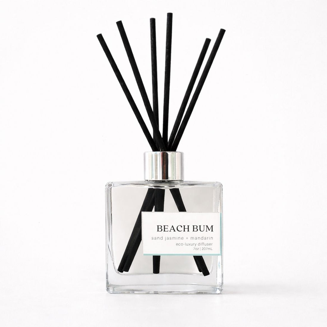 Clear diffuser bottle with black reeds labeled &