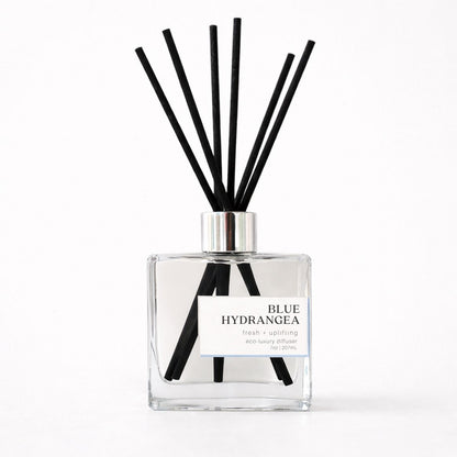 Green Koala Blue Hydrangea non-toxic reed diffuser with black fiber reeds on a white background
