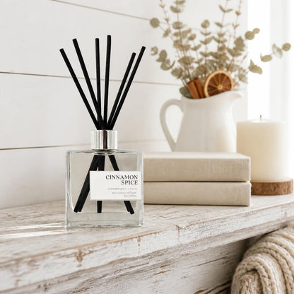 Green Koala Cinnamon Spice non-toxic reed diffuser on a white farmhouse mantel with linen books and a knit throw