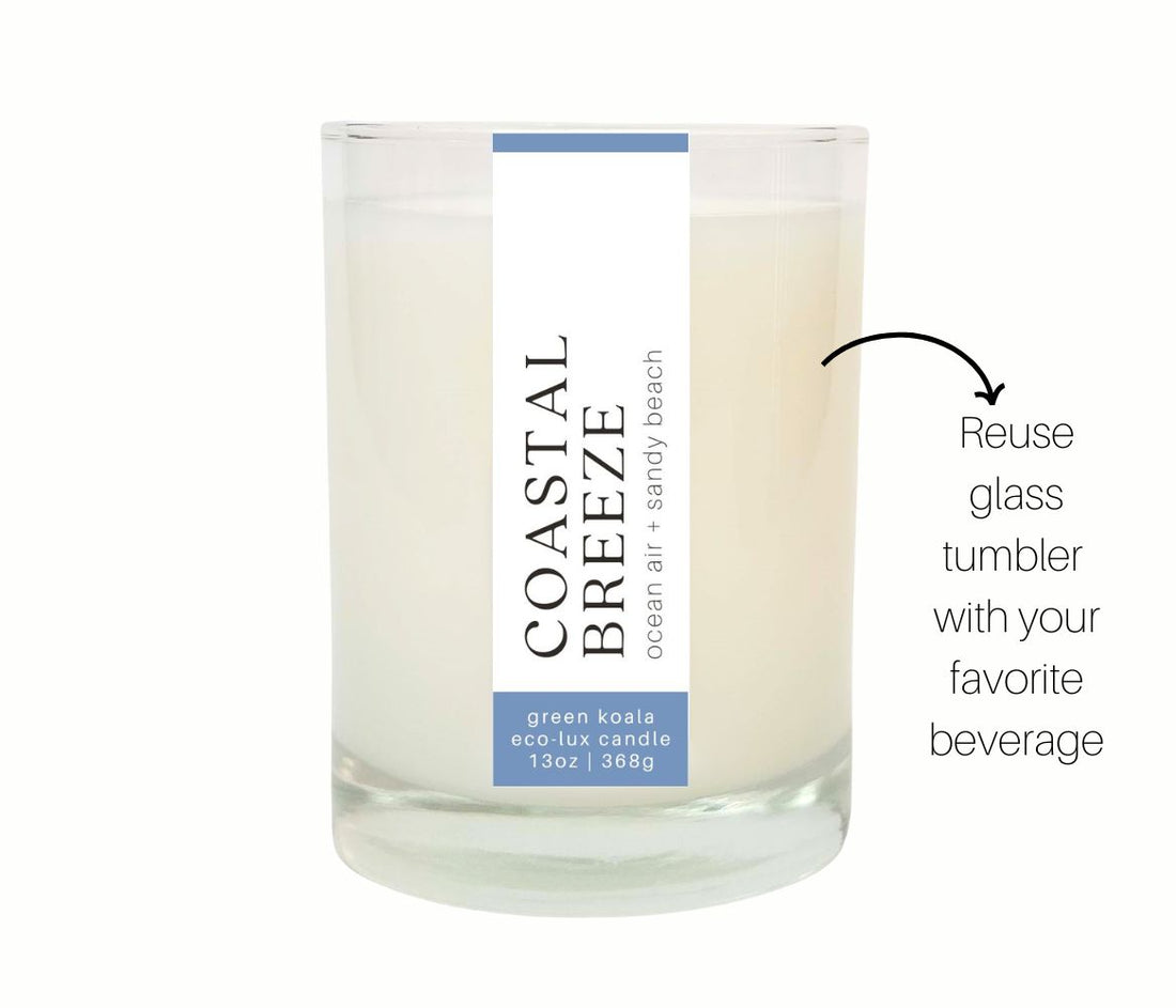 Candle in a glass tumbler with a label on a white background