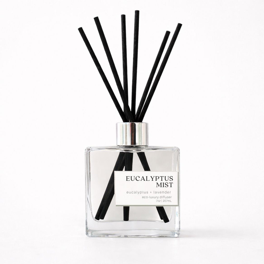 Clear diffuser bottle with black reeds labeled &