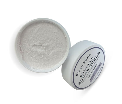 9oz Lavender Sugar Body Scrub jar with lid leaning on side, showcasing whipped texture and calming floral scent, exfoliates and hydrates skin.