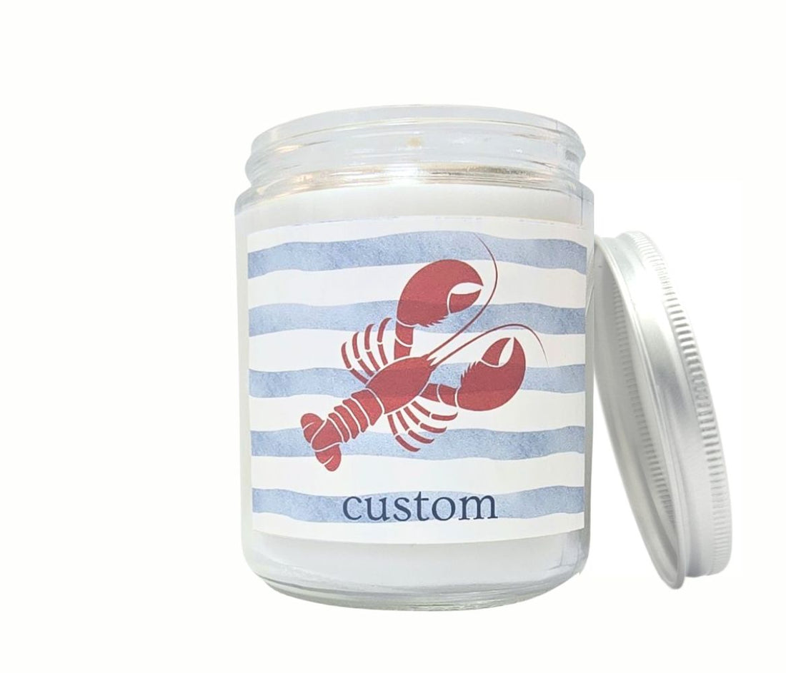 Custom 8oz coastal candle with red lobster icon and personalized beach town label on nautical blue striped background.