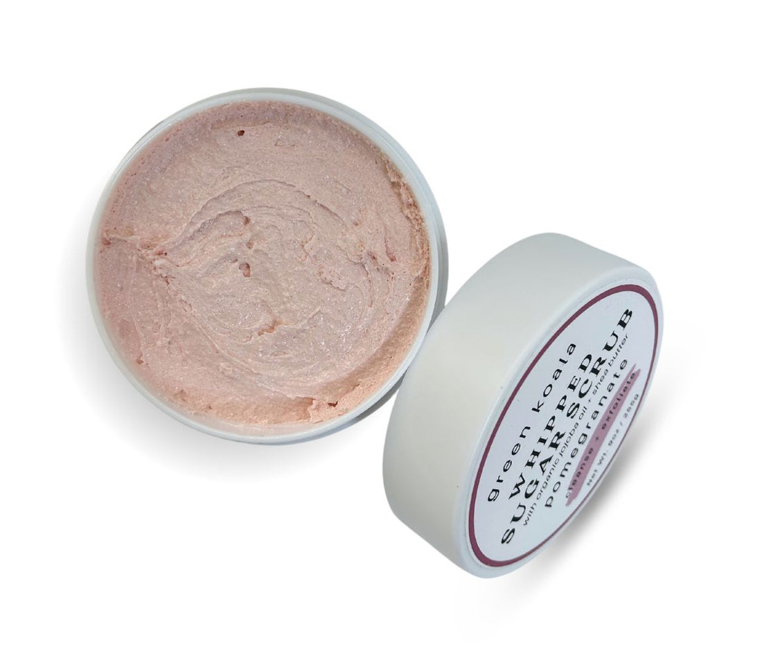 9oz Pomegranate Sugar Body Scrub jar with lid leaning on side, showcasing whipped texture and sweet aroma, cleanses, exfoliates, and deeply hydrates skin.