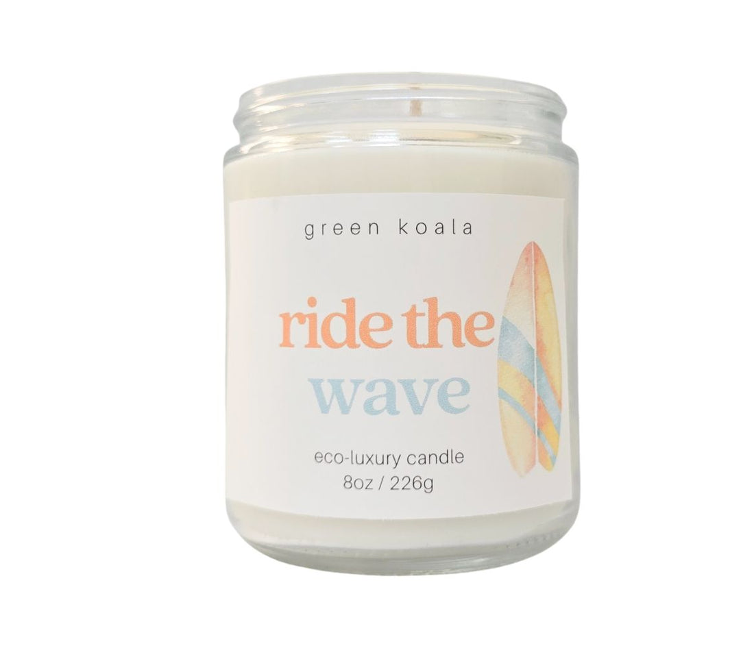 Ride the Wave candle with lid removed, displaying smooth coconut wax surface and surf-inspired label on glass jar.