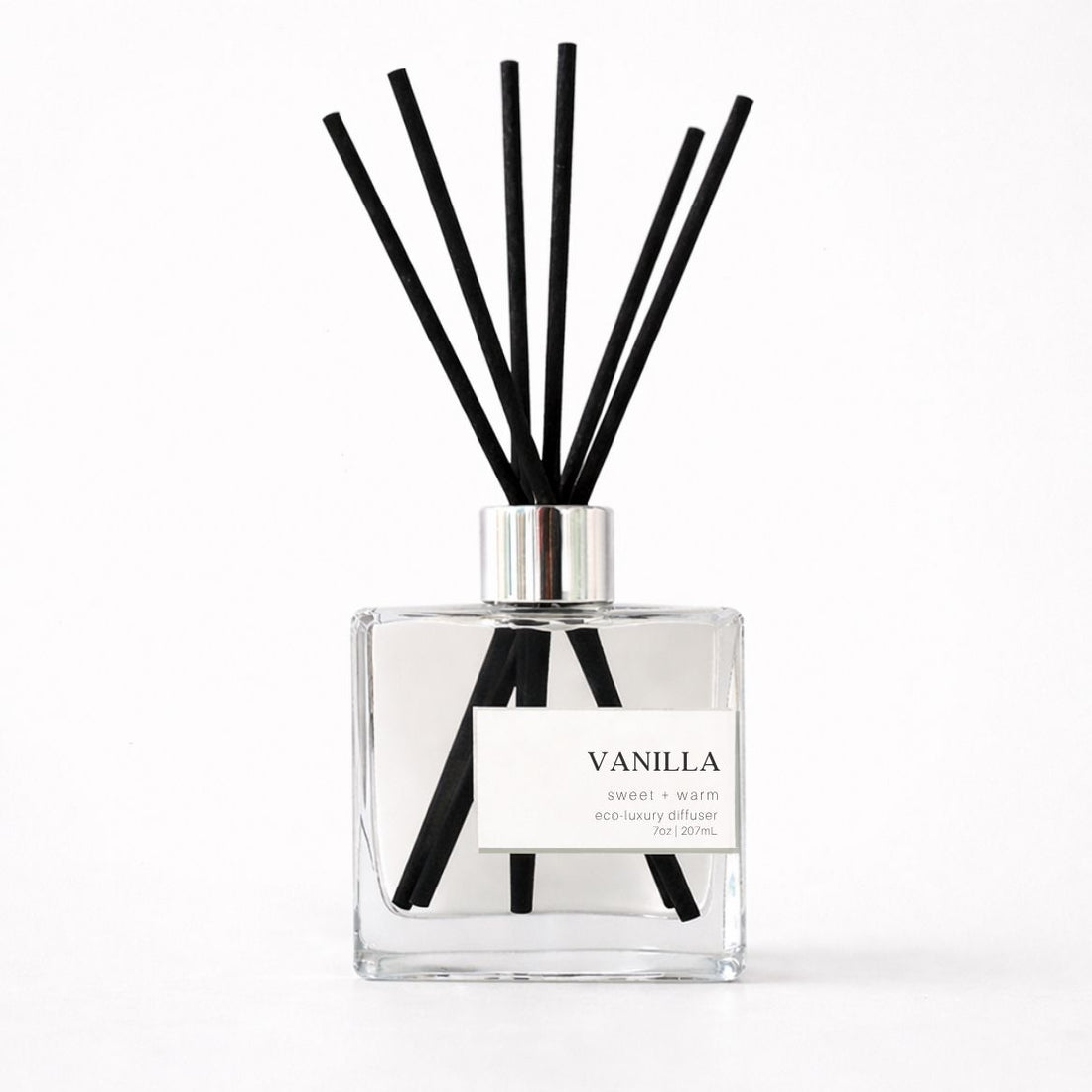 Clear diffuser bottle with black reeds labeled &